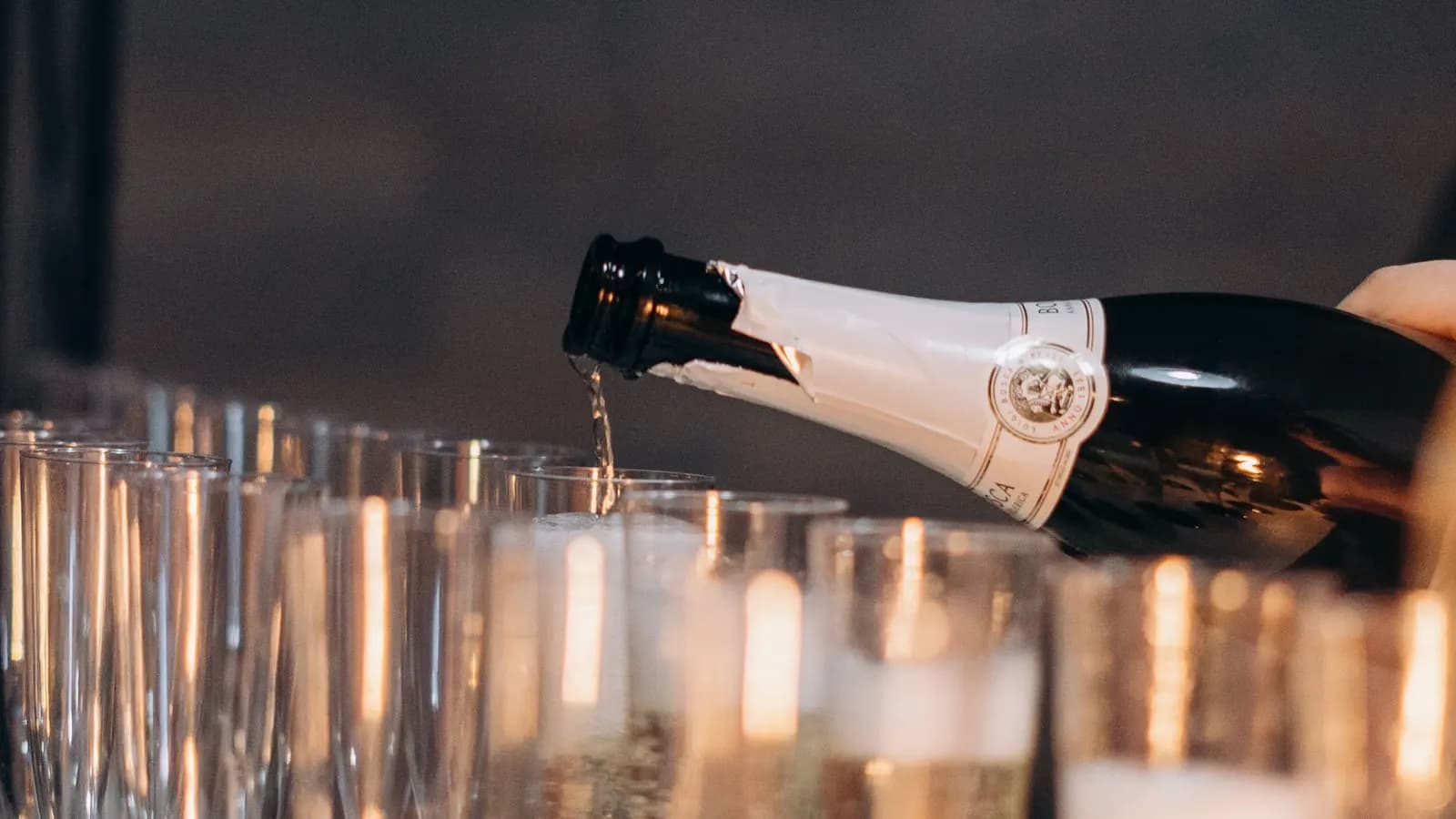 Sekt wird bei einem Empfang in bereitstehende Gläser eingeschenkt