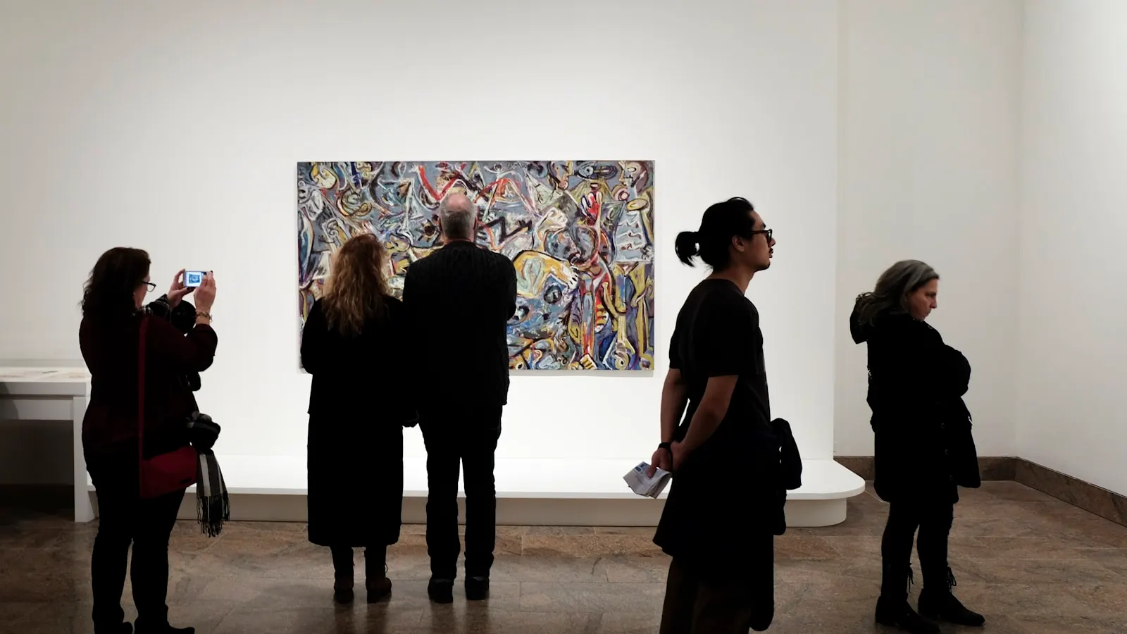 Besucherinnen und Besucher betrachten Bilder in einer Galerie